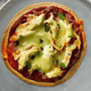 Mini pizza topped with chicken, brie and cranberry sauce